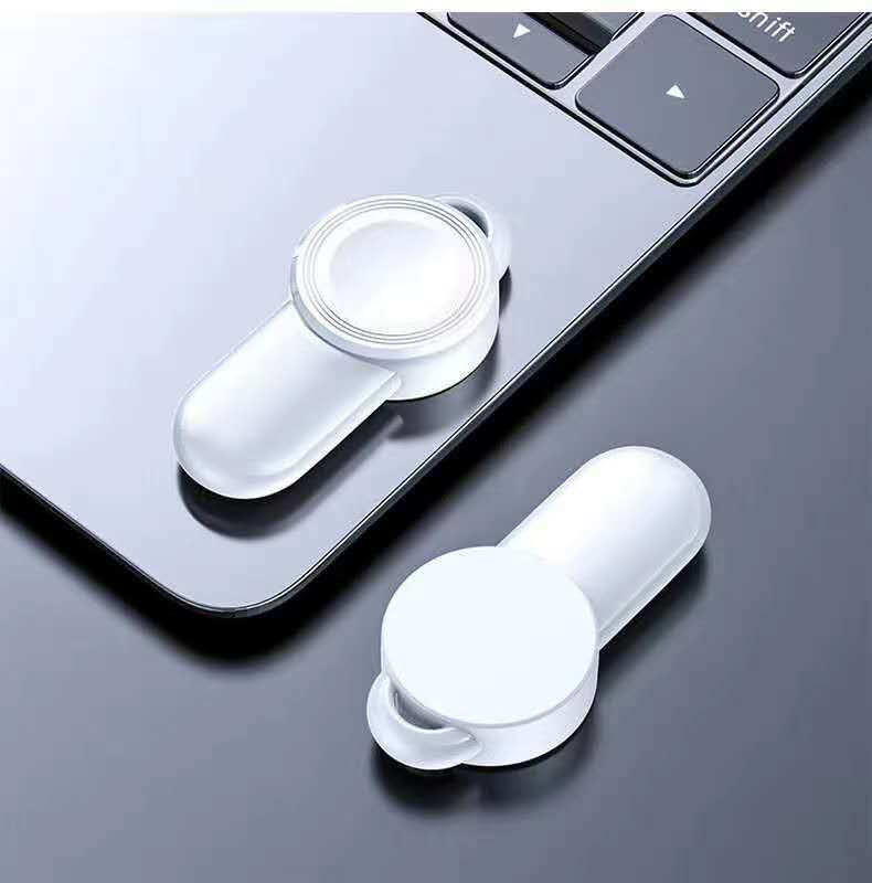 A USB wireless charging station on a nightstand with a smartphone charging wirelessly.